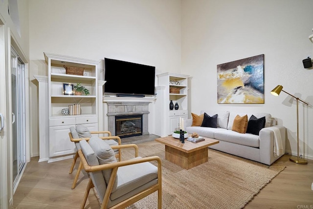 2935 Via Emerado, Carlsbad, CA 92009 - living room with light wood finished floors, a glass covered fireplace, a high ceiling, and baseboards