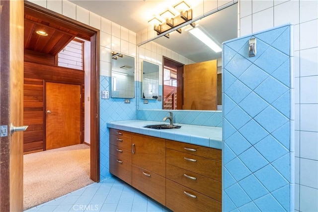 bathroom featuring tile patterned flooring, vanity, and tile walls