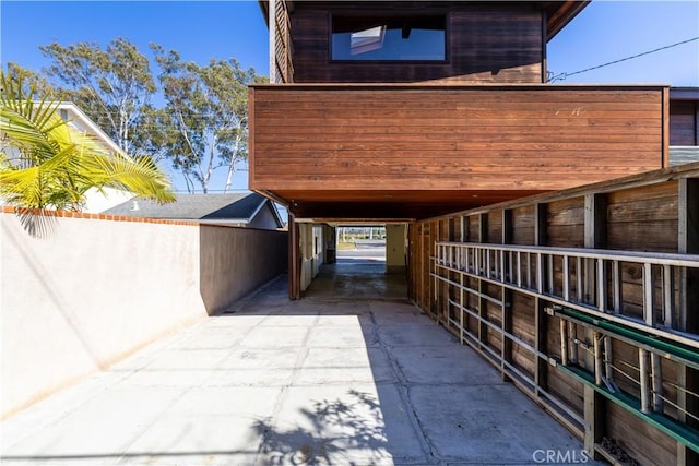 view of side of home featuring concrete driveway, an exterior structure, and an outdoor structure