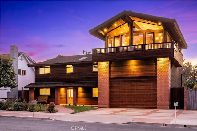contemporary home with a balcony, driveway, and a garage