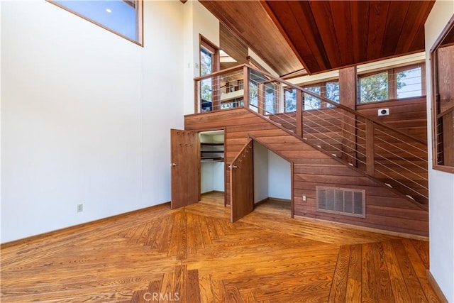 stairway featuring healthy amount of natural light and wooden ceiling