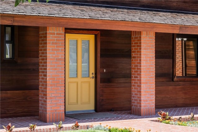 entrance to property featuring brick siding