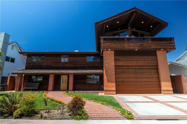 2405 Tustin Ave, Costa Mesa, CA 92627 - view of front of property with a balcony, concrete driveway, brick siding, and covered porch