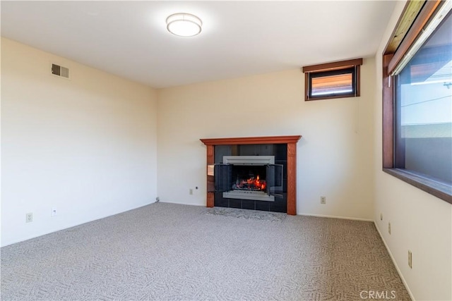 unfurnished living room with carpet floors and a fireplace