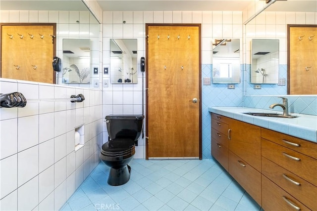 bathroom with tile walls, tile patterned flooring, vanity, and toilet