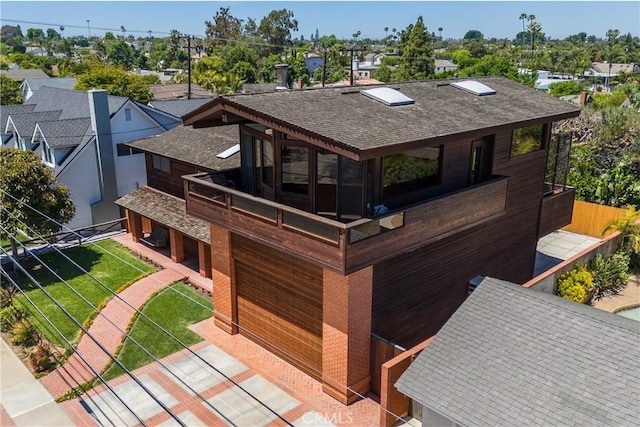 view of front of house featuring a shingled roof, a residential view, and a front lawn