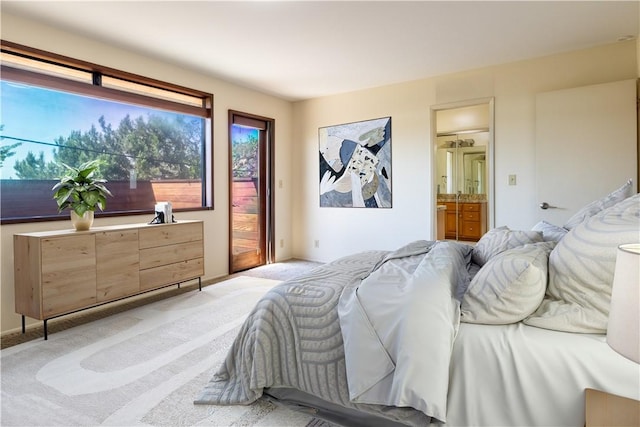 bedroom with light colored carpet, access to exterior, and ensuite bath