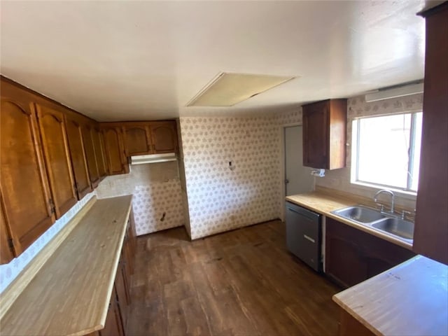 kitchen with dishwashing machine, a sink, dark wood-style flooring, and light countertops