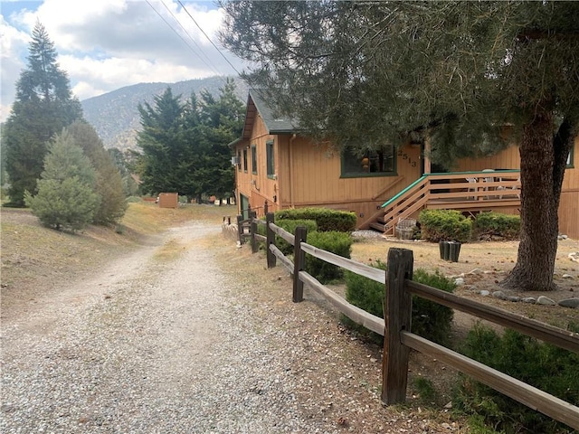 2513 Arbor Dr, Pine Mountain Club, CA 93225 - view of home's exterior with gravel driveway, a mountain view, and fence