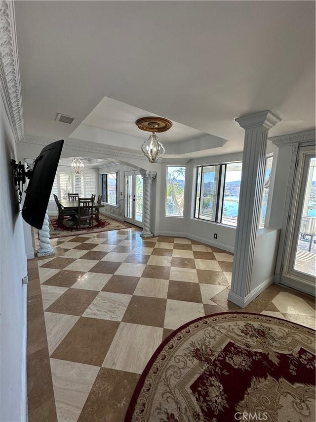 22564 Inspiration Pt, Canyon Lake, CA 92587 - entryway with ornate columns, a tray ceiling, a chandelier, and healthy amount of natural light