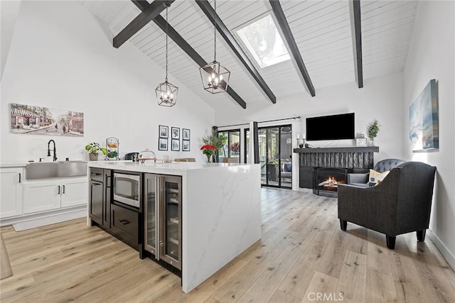 2514 N Tustin Ave Unit 71, Santa Ana, CA 92705 - kitchen with stainless steel microwave, a sink, wine cooler, beam ceiling, and a chandelier