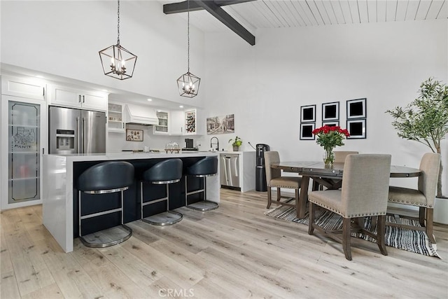 2514 N Tustin Ave Unit 71, Santa Ana, CA 92705 - kitchen with stainless steel appliances, a center island, a chandelier, high vaulted ceiling, and light wood finished floors