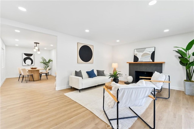 2514 S Rita Way, Santa Ana, CA 92704 - living area with light wood-style flooring, baseboards, recessed lighting, and a fireplace with raised hearth