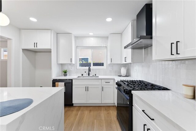 2514 S Rita Way, Santa Ana, CA 92704 - kitchen with black appliances, wall chimney range hood, a sink, white cabinetry, and light wood finished floors
