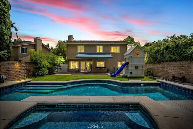 24441 Indian Hill Ln, West Hills, CA 91307 - pool at dusk featuring a patio area, a fenced backyard, and a playground