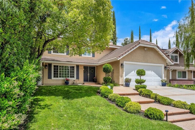 24441 Indian Hill Ln, West Hills, CA 91307 - view of front of home featuring stucco siding, a front lawn, a garage, driveway, and a tile roof