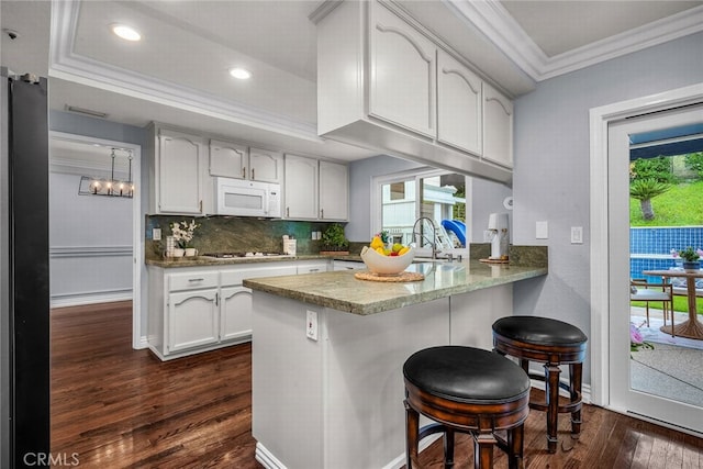 24441 Indian Hill Ln, West Hills, CA 91307 - kitchen featuring white microwave, crown molding, a peninsula, freestanding refrigerator, and gas stovetop