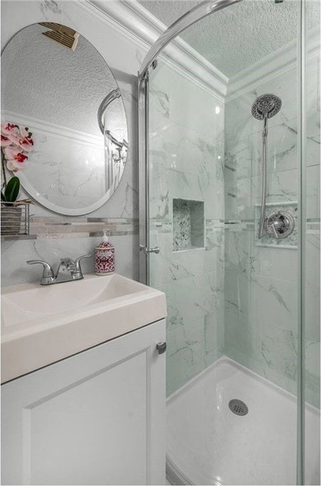 24441 Indian Hill Ln, West Hills, CA 91307 - bathroom featuring a textured ceiling, ornamental molding, a marble finish shower, and vanity