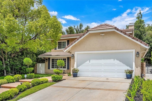 24441 Indian Hill Ln, West Hills, CA 91307 - view of front of house with an attached garage, a tiled roof, concrete driveway, and stucco siding