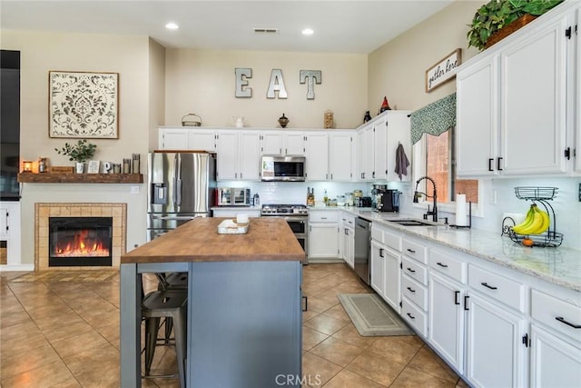 25515 Mountain Springs St, Menifee, CA 92584 - kitchen with appliances with stainless steel finishes, a sink, wood counters, white cabinets, and recessed lighting