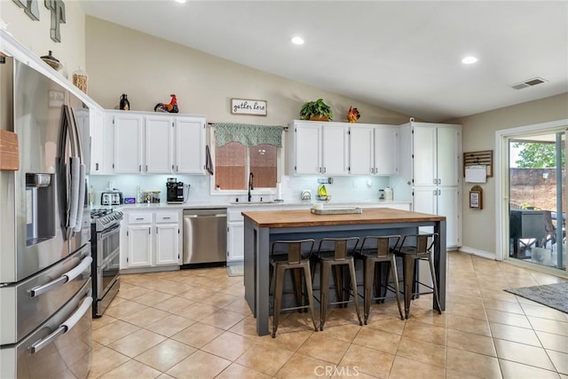 25515 Mountain Springs St, Menifee, CA 92584 - kitchen with stainless steel appliances, vaulted ceiling, butcher block counters, a sink, and white cabinets