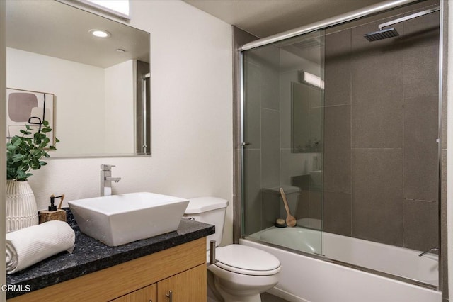bathroom with toilet, enclosed tub / shower combo, and vanity