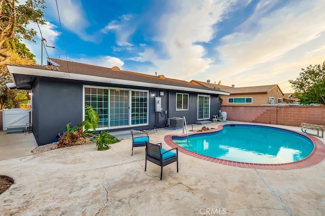 back of house with central air condition unit, stucco siding, a patio, a fenced backyard, and a gate