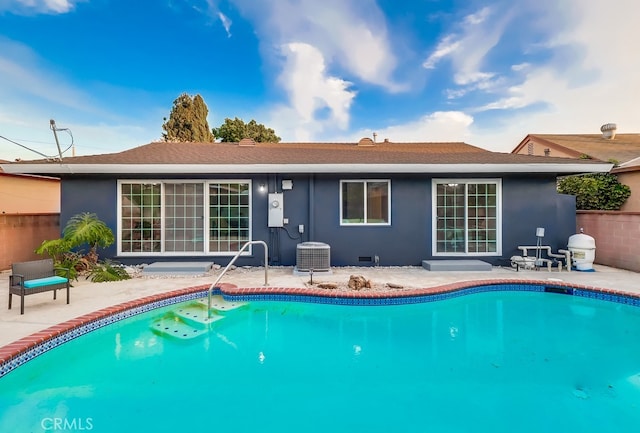 back of house with central AC, an outdoor pool, and a patio