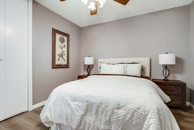 bedroom featuring wood finished floors, baseboards, and a ceiling fan