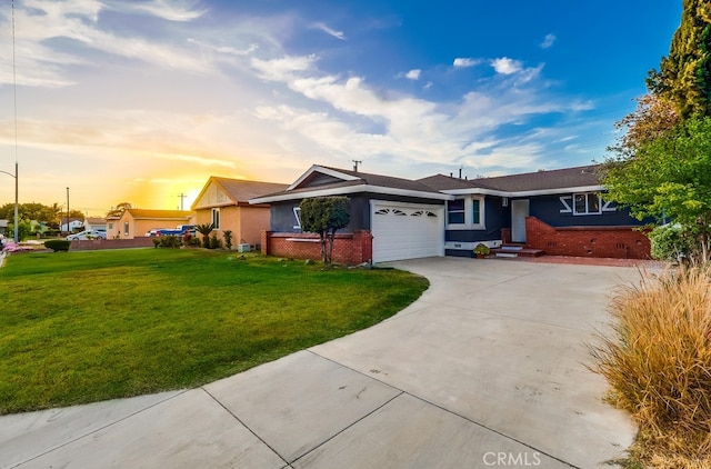 single story home featuring a front yard, driveway, a garage, brick siding, and stucco siding