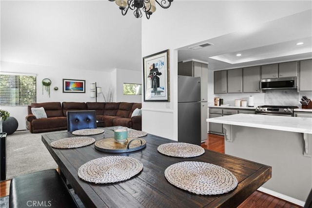 5740 Violeta Ave, Atascadero, CA 93422 - dining room with dark wood-style floors, recessed lighting, a chandelier, and a tray ceiling
