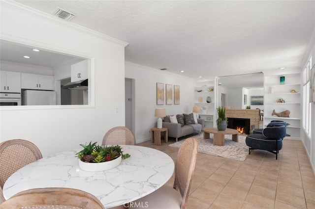 1710 Plaza Del Norte, Newport Beach, CA 92661 - dining room featuring built in shelves, light tile patterned flooring, crown molding, a lit fireplace, and recessed lighting