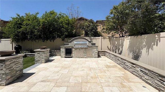 14247 Symphony Ct, Eastvale, CA 92880 - view of patio with an outdoor kitchen and a fenced backyard