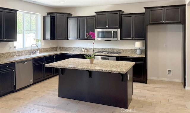14247 Symphony Ct, Eastvale, CA 92880 - kitchen with appliances with stainless steel finishes, a sink, a kitchen island, a breakfast bar area, and recessed lighting