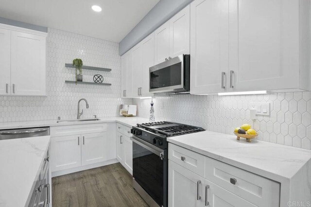 1444 Wooden Valley St, Chula Vista, CA 91913 - kitchen with appliances with stainless steel finishes, open shelves, backsplash, dark wood-style floors, and white cabinets