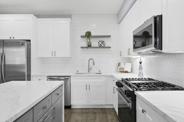 1444 Wooden Valley St, Chula Vista, CA 91913 - kitchen with stainless steel appliances, dark wood-type flooring, white cabinetry, and decorative backsplash