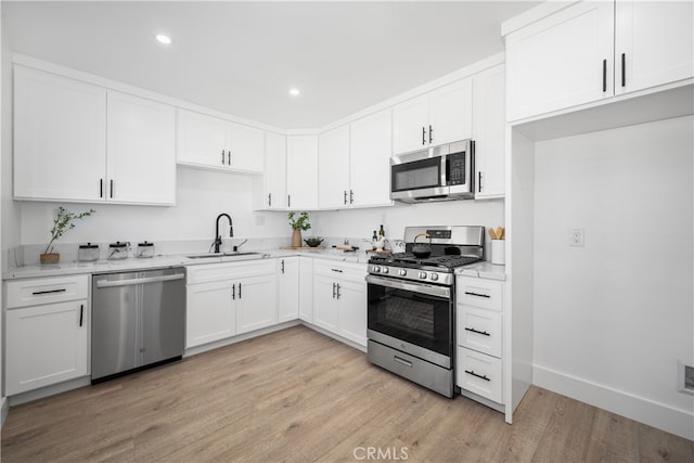 6131 Chickasaw Dr, Westminster, CA 92683 - kitchen featuring stainless steel appliances, a sink, light stone counters, light wood finished floors, and white cabinets