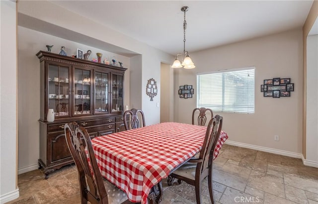 7840 La Cresta St, Highland, CA 92346 - dining space featuring stone tile flooring, baseboards, and a chandelier