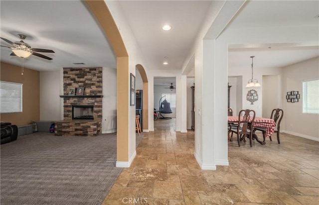 7840 La Cresta St, Highland, CA 92346 - hall with stone tile flooring, baseboards, arched walkways, recessed lighting, and a chandelier