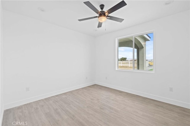 empty room featuring baseboards, wood finished floors, and a ceiling fan