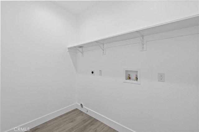 clothes washing area with hookup for a washing machine, wood finished floors, baseboards, electric dryer hookup, and hookup for a gas dryer