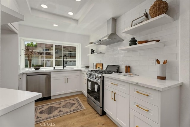 8 Galanto, Irvine, CA 92614 - kitchen with open shelves, stainless steel appliances, a sink, wall chimney range hood, and light wood-type flooring
