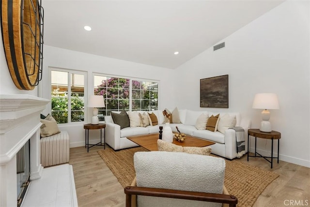8 Galanto, Irvine, CA 92614 - living area with lofted ceiling, light wood-style floors, baseboards, recessed lighting, and a fireplace with raised hearth