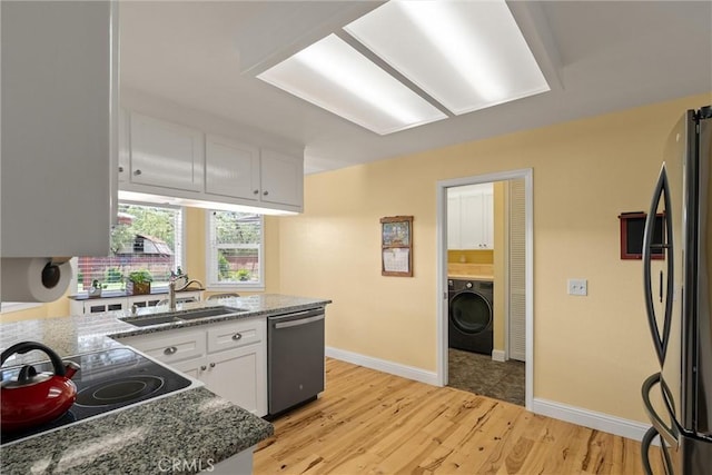 40 Gunter Ln, Oroville, CA 95966 - kitchen featuring stainless steel appliances, washer / dryer, white cabinets, a sink, and light wood finished floors