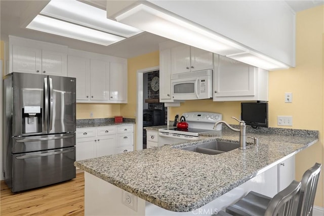 40 Gunter Ln, Oroville, CA 95966 - kitchen with white appliances, a peninsula, a sink, light wood finished floors, and white cabinetry