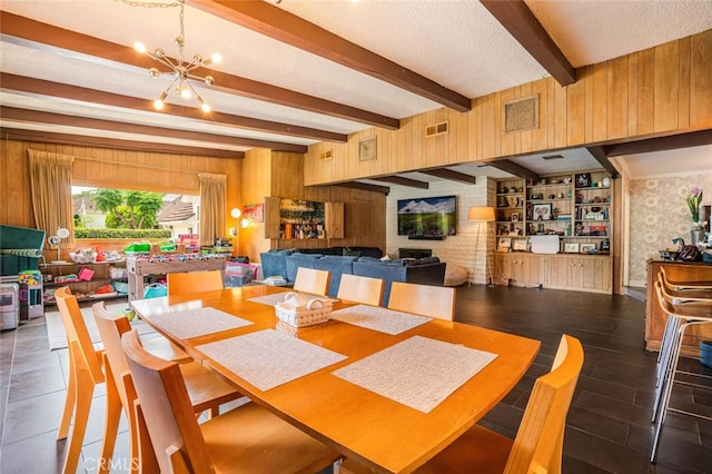 6616 Langdon Ave, Van Nuys, CA 91406 - dining room with beamed ceiling, a chandelier, a textured ceiling, and wood walls
