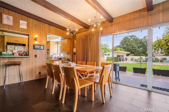 6616 Langdon Ave, Van Nuys, CA 91406 - dining area with a chandelier, beam ceiling, wooden walls, plenty of natural light, and a textured ceiling