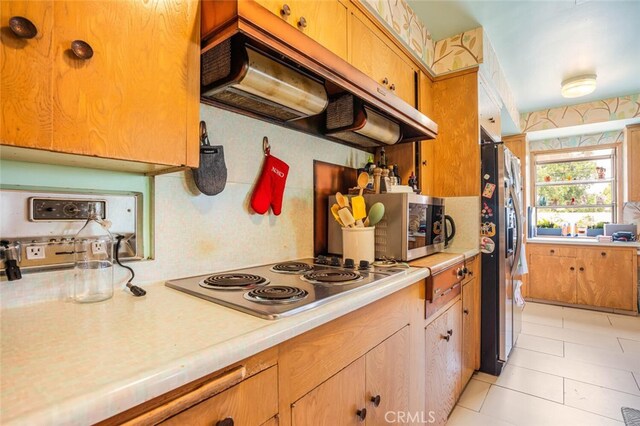 6616 Langdon Ave, Van Nuys, CA 91406 - kitchen featuring under cabinet range hood, stainless steel appliances, light countertops, and light tile patterned flooring