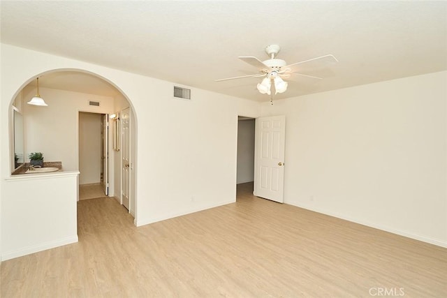 8068 Catherine Ave Unit 9, Stanton, CA 90680 - empty room with light wood finished floors, arched walkways, and ceiling fan