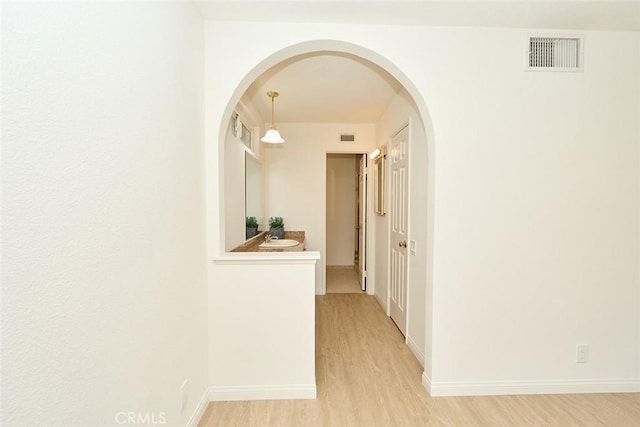 8068 Catherine Ave Unit 9, Stanton, CA 90680 - corridor with light wood-type flooring, arched walkways, and baseboards